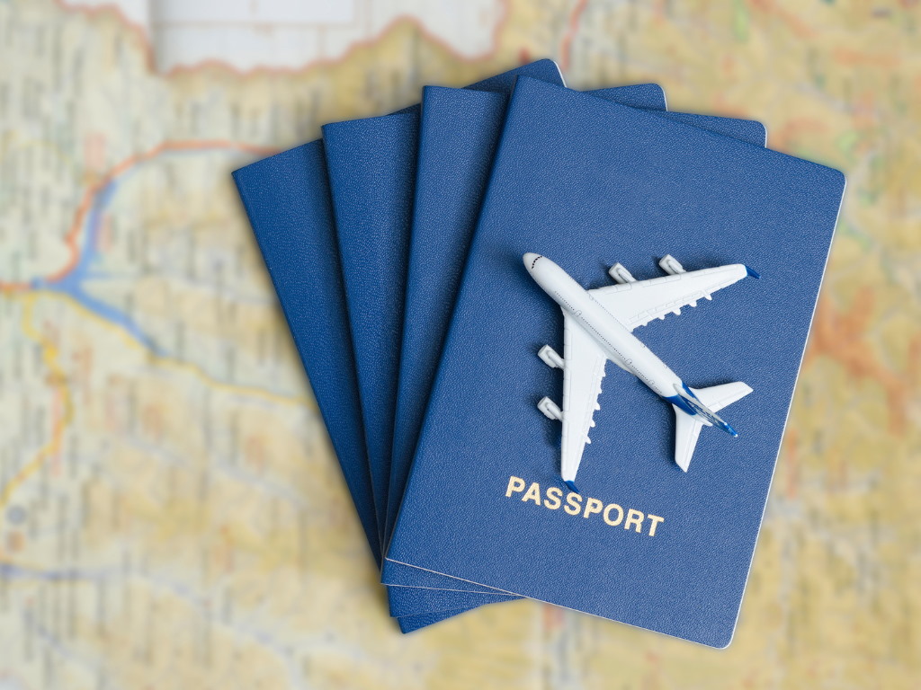 Three passports and a model aeroplane positioned on a map
