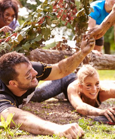 Participants overcoming obstacles on an assault course