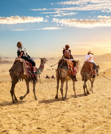 Tourist riding a camel in the desert