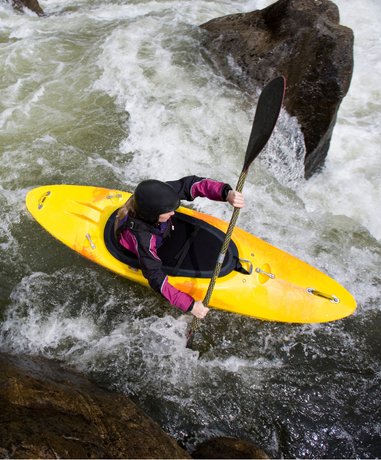 Canoeist navigating rough river waters