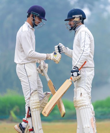 Cricket player batting in full gear