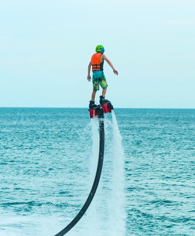 Flyboarder performing aerial maneuvers over water