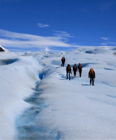 Glacier walker equipped with crampons and ice axe