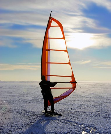 Ice windsurfer gliding on a frozen lake