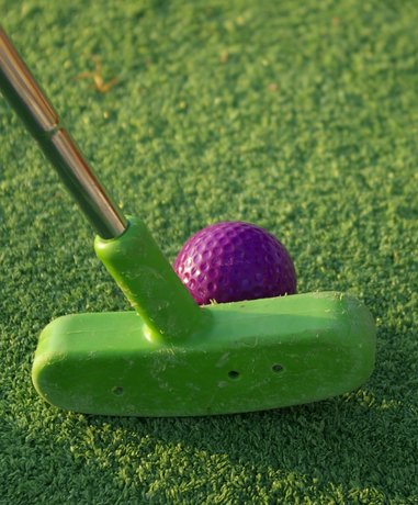 Mini golf player aiming on a colorful course