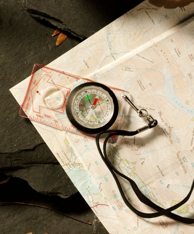 Orienteering participant using map and compass