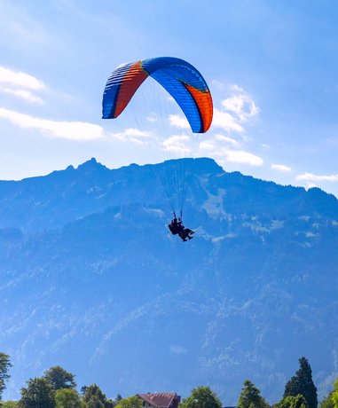Parascending in action over a scenic landscape