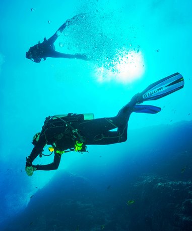 Diver with mixed gas tanks preparing for a dive