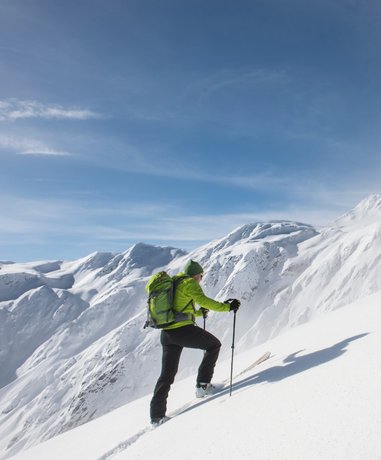 Ski tourer ascending a snowy slope
