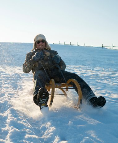 Sledger sliding down a snowy hill