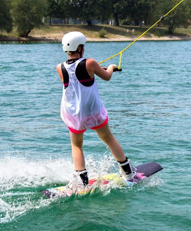 Wake boarder performing a trick on a lake
