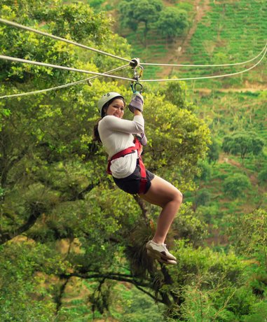 Zip lining enthusiast gliding over a forest